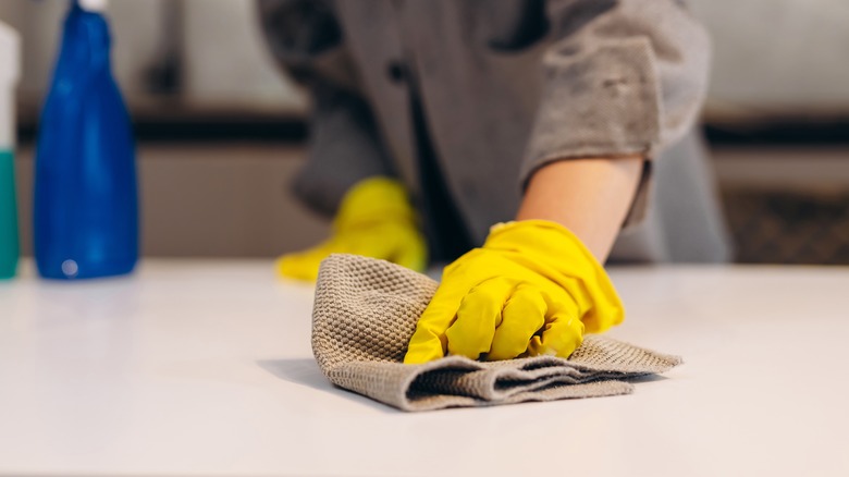 Person cleaning white tabletop