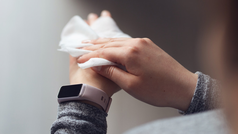 Person wiping hand with cloth