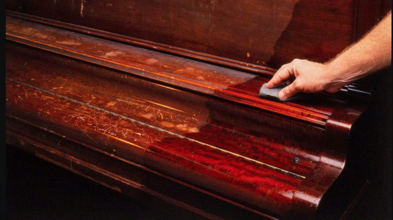 Someone using Restor-A-Finish on an old wooden piano