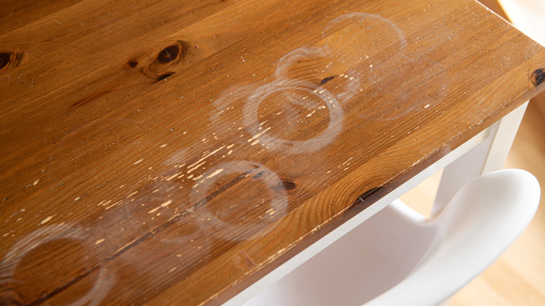 Scratched and worn wooden table with white rings