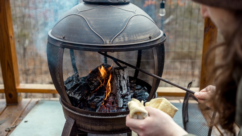 Person tending fire in pit