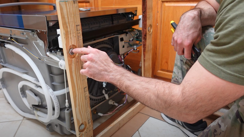 man prepping dishwasher for installation