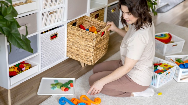 Woman sorting child's toy bins