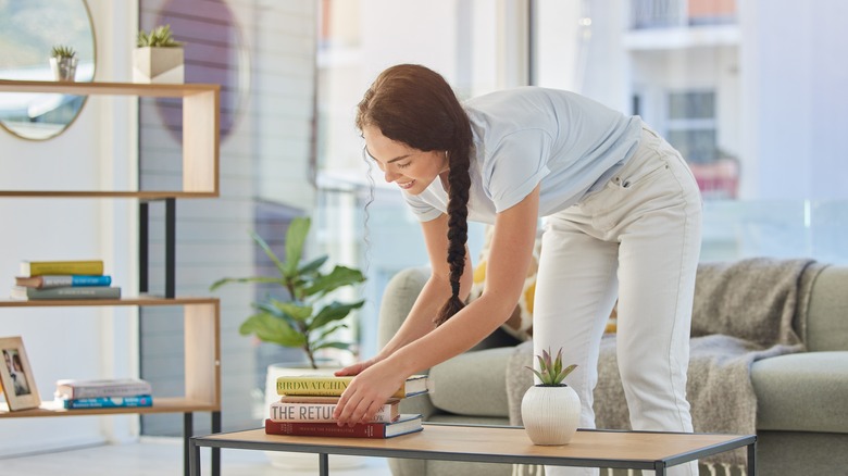 Person stacking book collection