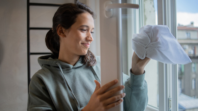 Woman cleaning windows with cloth