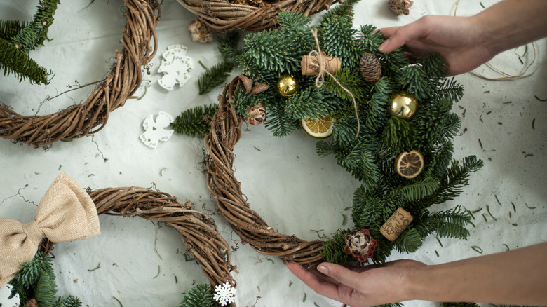hands holding decorated holiday wreath