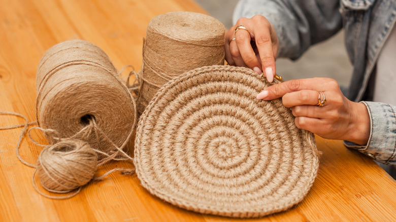 person crocheting twine placemat