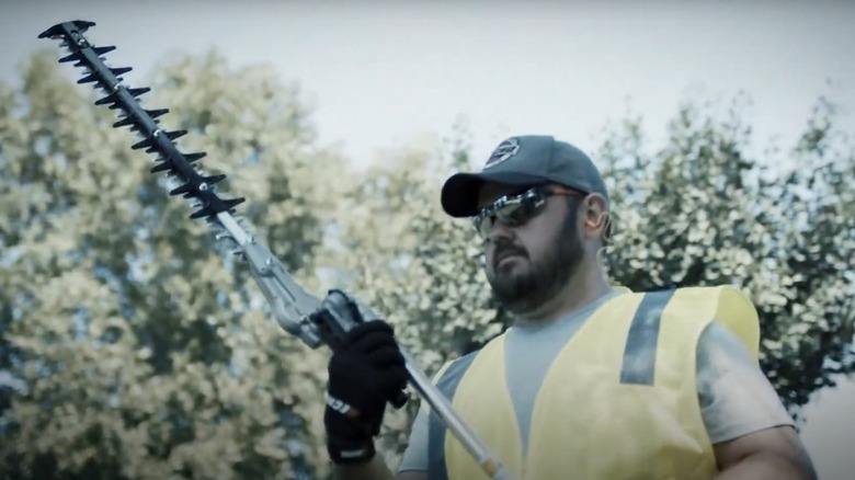 man using hedge trimmer attachment on Echo weed eater