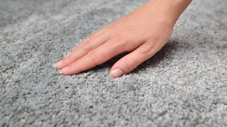 hand on gray carpet