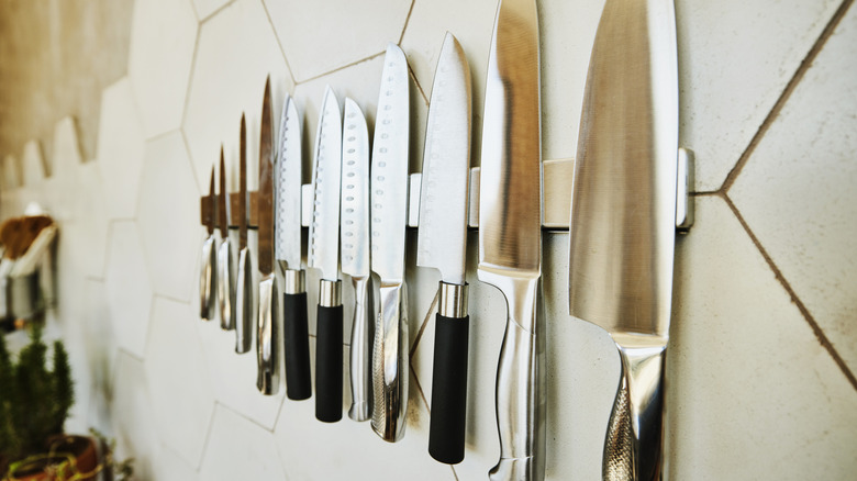 A row of kitchen knives hanging on the wall