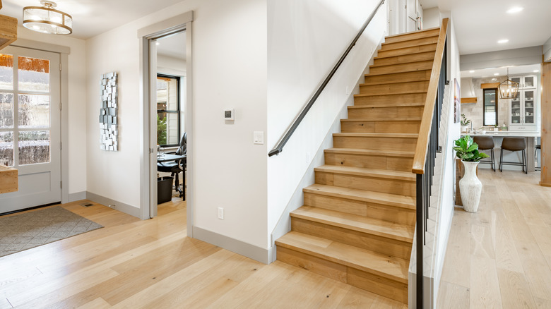 A plain wooden staircase in a modern home with hardwood floors