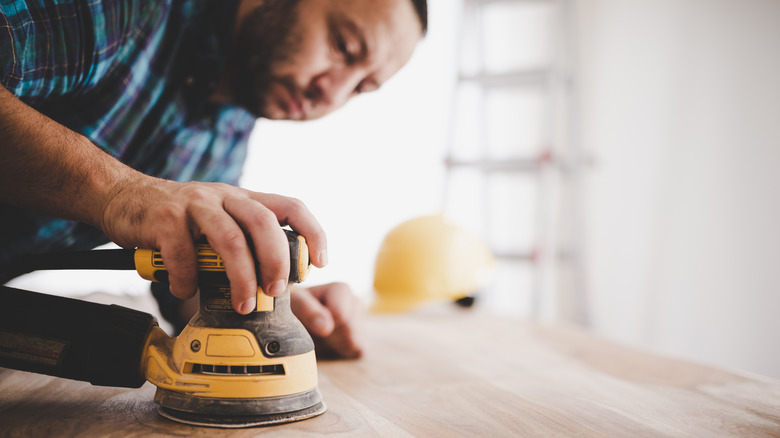 man using electric sander