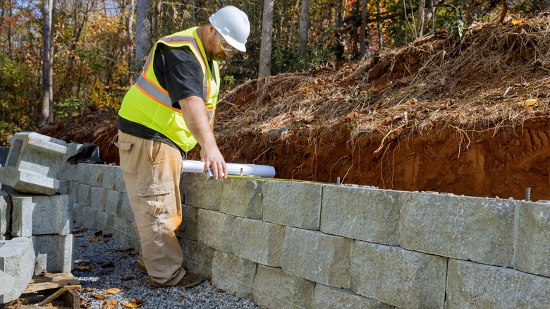 A block retaining wall being built by a contractor