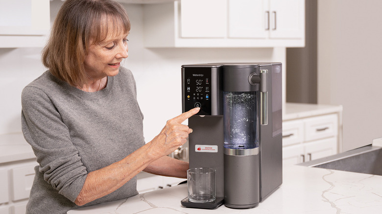 Woman pressing button on Waterdrop Filter's A2 reverse osmosis dispenser