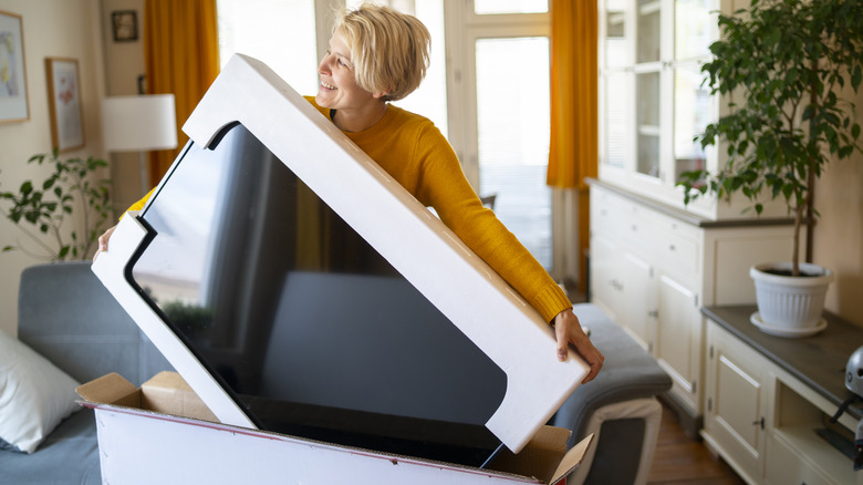 woman lifting new TV