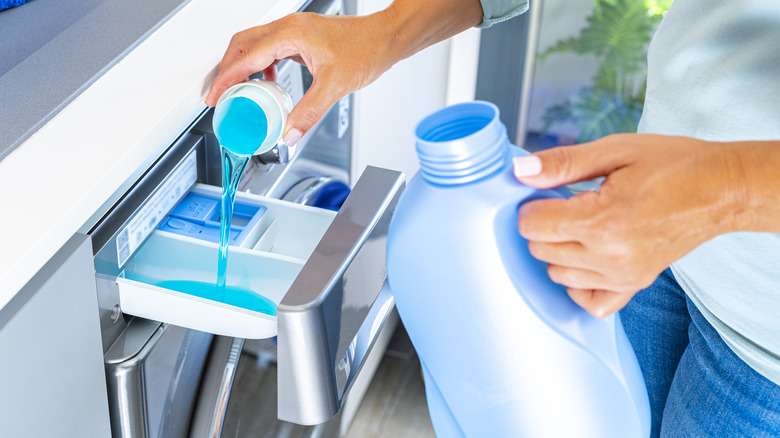 Woman pouring detergent into washer