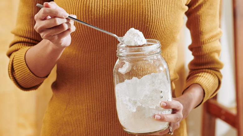 Woman scooping out baking soda 