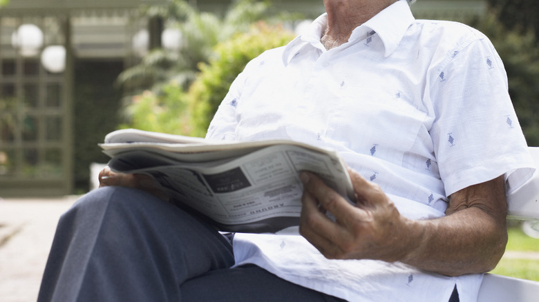 Man sitting and reading newspaper