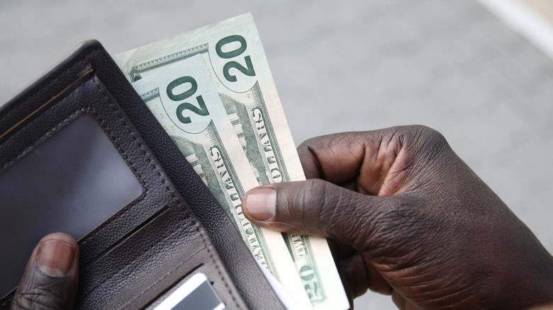 Person pulling cash out of wallet