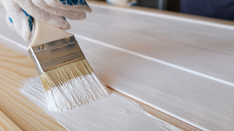 person painting wood trim