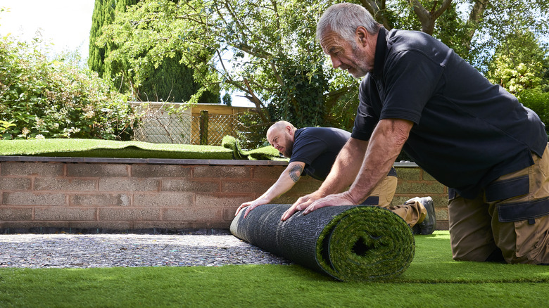 Two men installing artificial grass