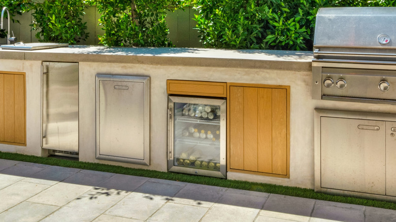 An outdoor kitchen with a refrigerator