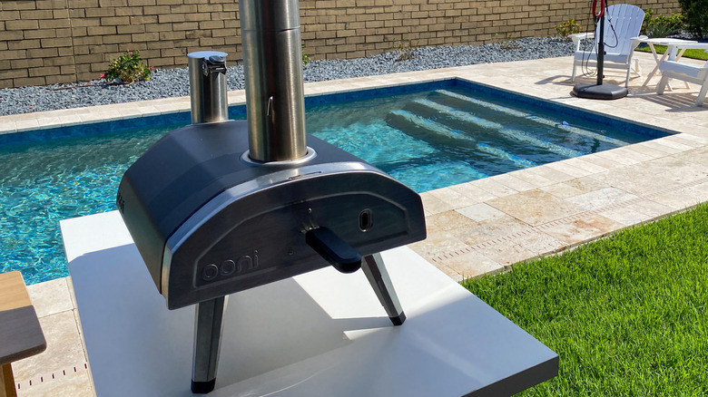 An outdoor pizza oven by a pool