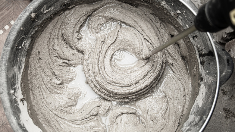 Mixing concrete in bucket closeup