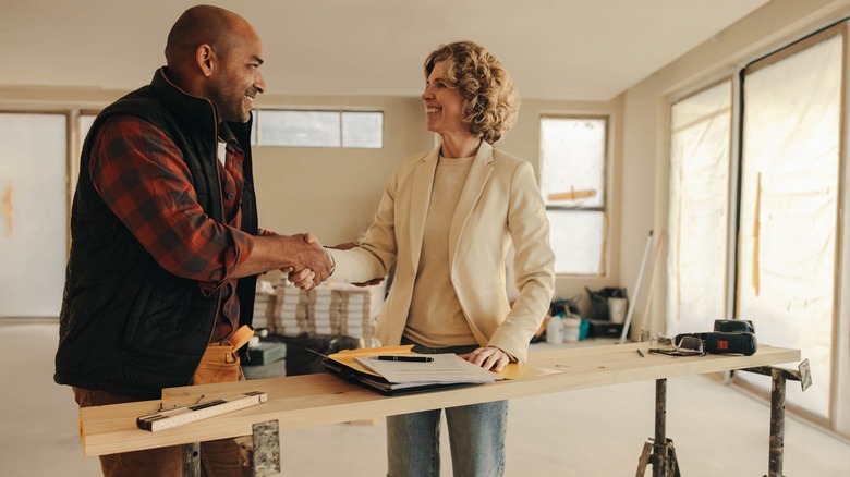 Homeowner and contractor shake hands over contract