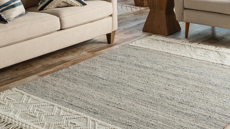 A clean living room is decorated with a pristine wool rug