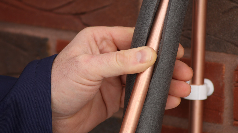 Man insulating a pipe