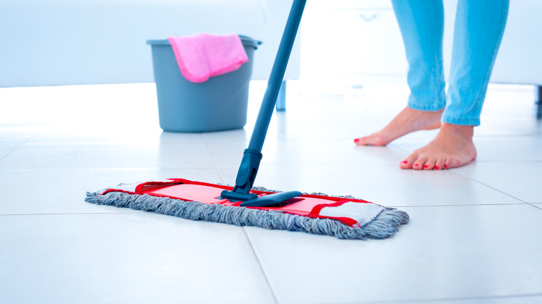 Woman cleaning tile floor with a mop