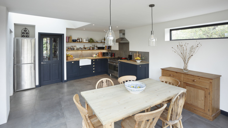 A kitchen and dining room with gray tile floors