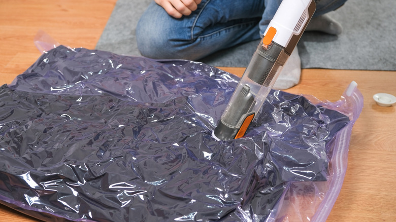 Man vacumm seals winter coats in a bag