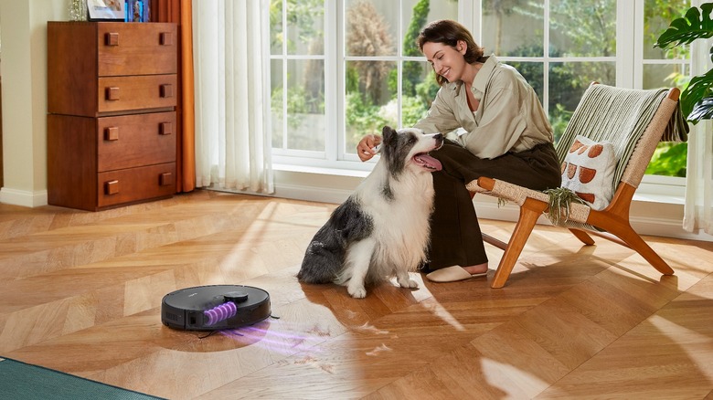 Vacuum beside woman petting dog