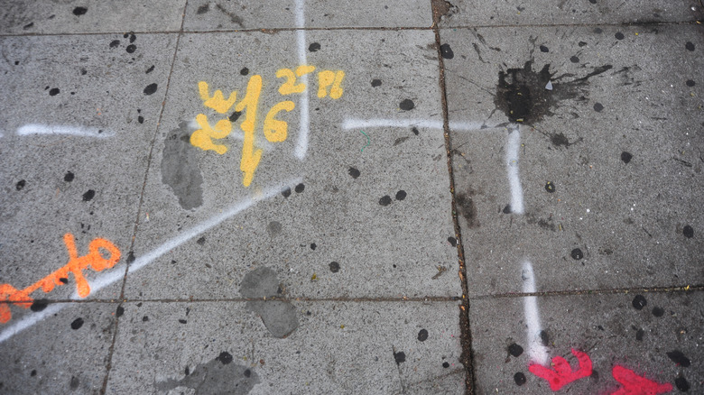 Yellow spray painted symbols on a city sidewalk