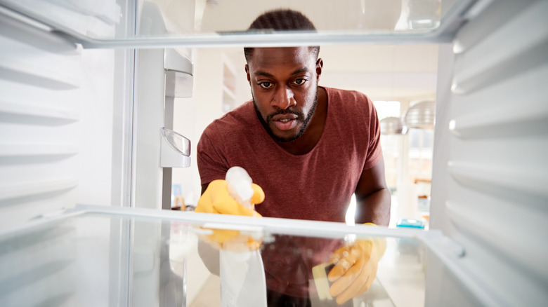 Man cleaning a refrigerator