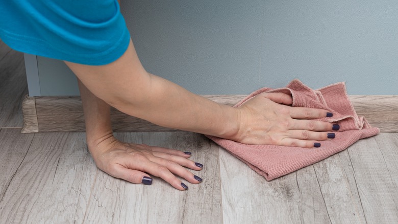 Wiping down the kitchen baseboards