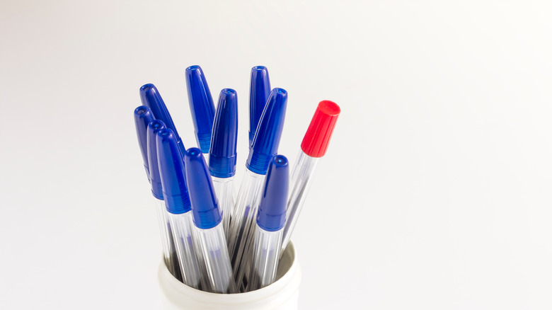 ballpoint pens with blue caps in white cup
