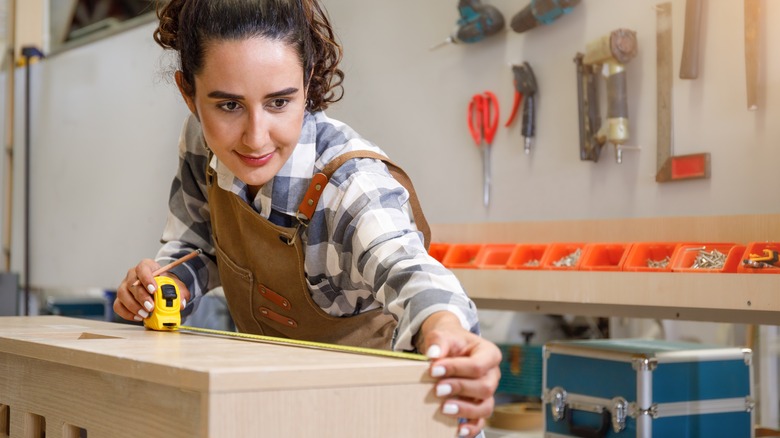 young woman using measuring tape