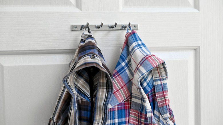 flannel shirts hanging on door hooks