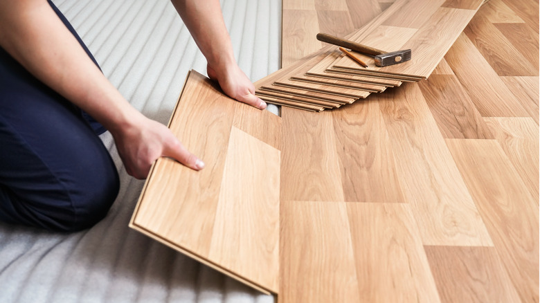 person installing laminate planks