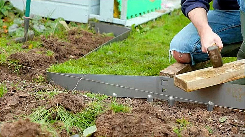 Person installing lawn metal edging