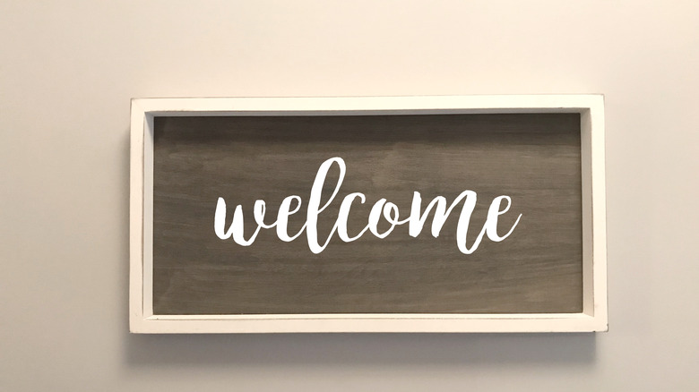 wooden welcome sign on wall