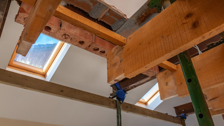 Supporting a load-bearing wall while a steel beam support is added