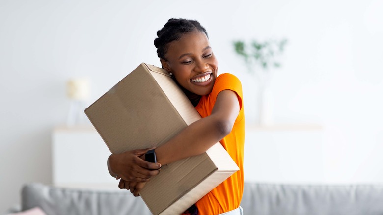 woman hugging cardboard package