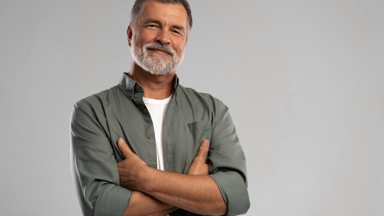 Senior man smiling arms folded