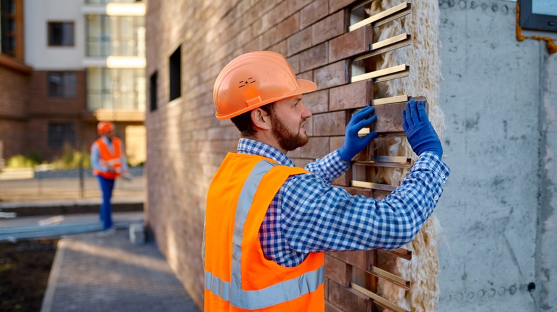 Worker installing stone cladding