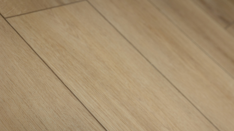 Light colored vinyl plank flooring is shown up close.