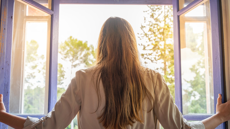 Woman opens a window.